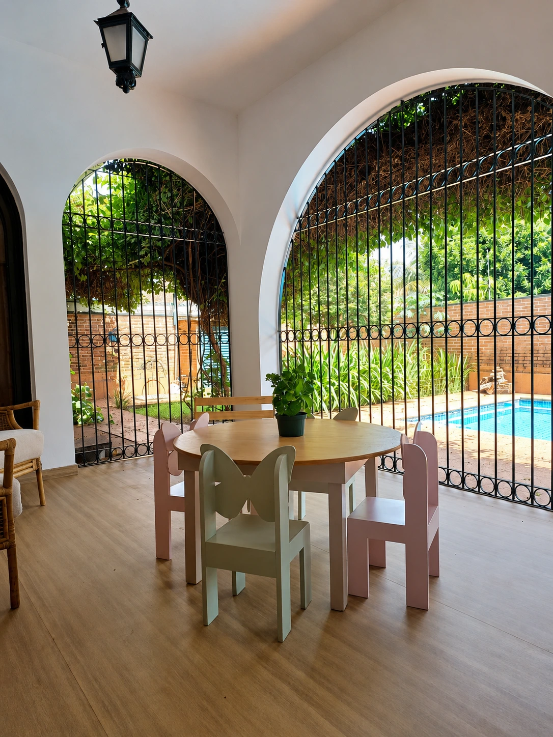 Varanda do Espaço Casulo com arcos, jardim e piscina ao fundo